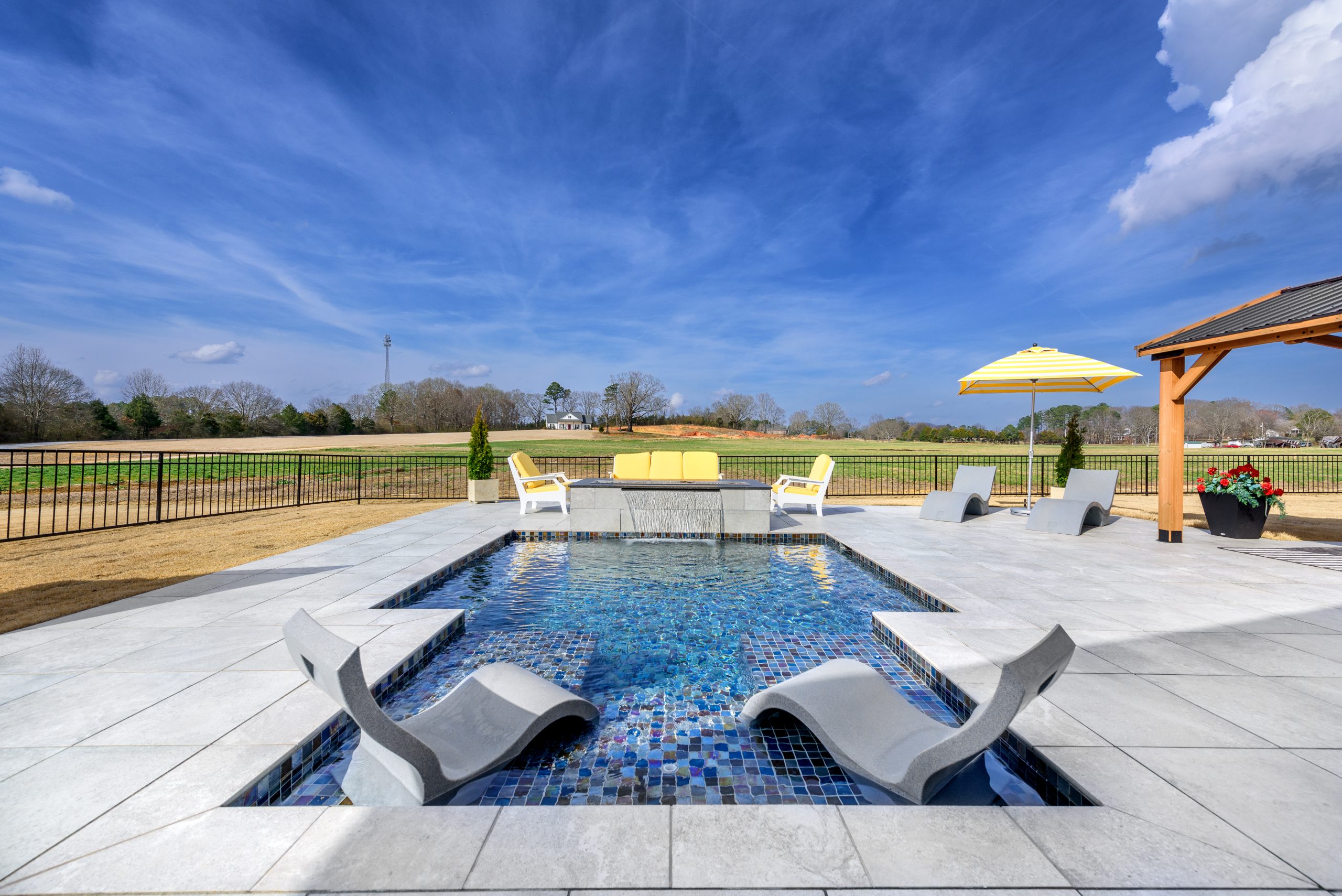 inground pool with sun loungers in backyard