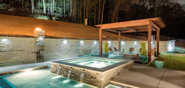 a cocktail pool with spa at night with low pool lighting