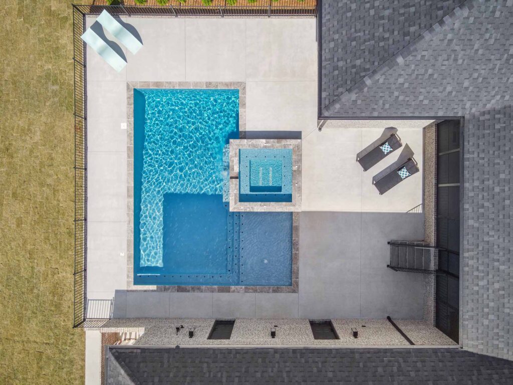 a geometric cocktail pool from above in concrete backyard